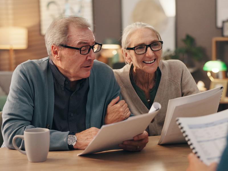 Elderly couple discussing financial documents.